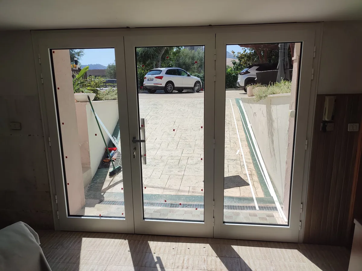 Porta finestra a tre ante in alluminio bianco con vista giardino — installazione IS Metal srl Abruzzo